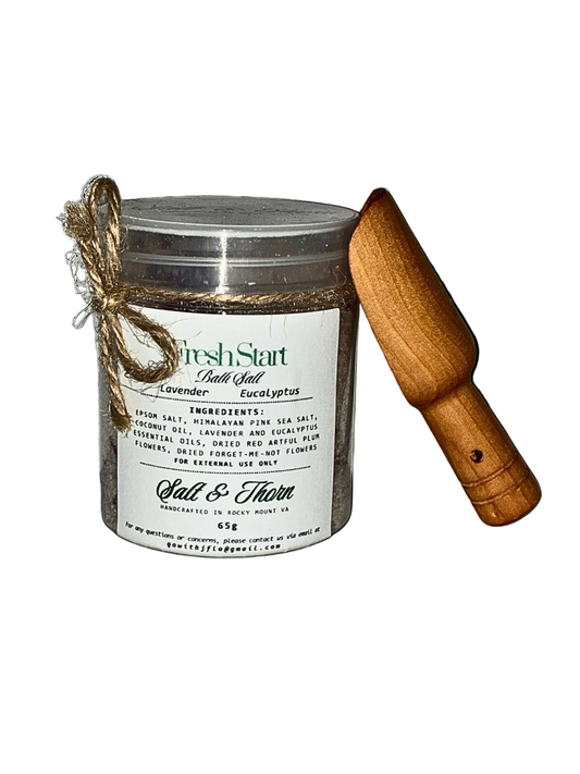 Tub of bath salt with wooden scoop on a white background