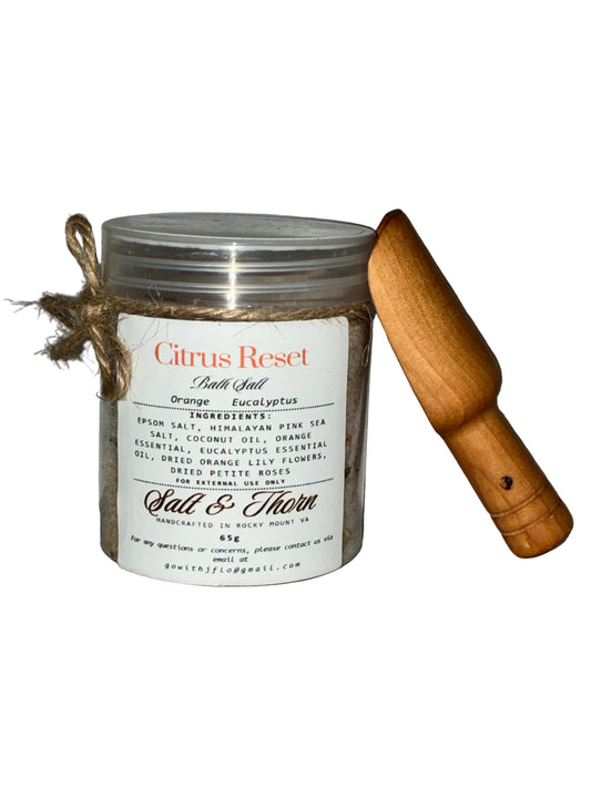 Candle in a glass jar with a wooden lid on a gray background