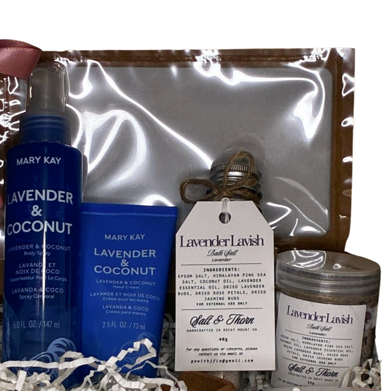 Mary Kay lavender and coconut products with a candle and salt product on a reflective surface.