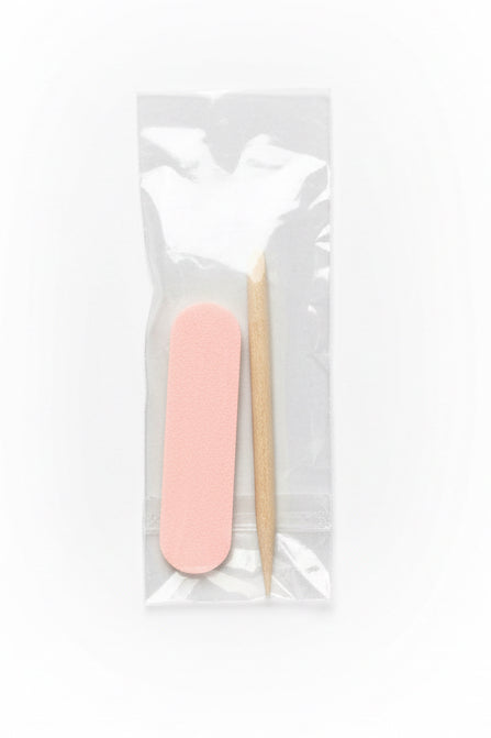 Pink nail file and wooden stick in a clear plastic bag on a white background