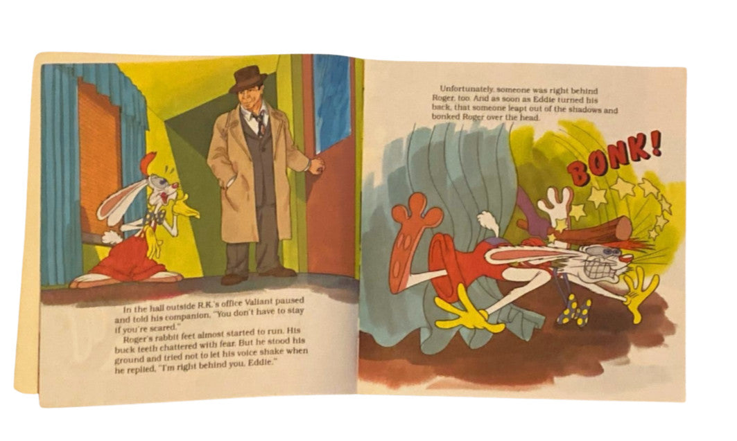 Open book with cartoon-style illustration of a character and rabbit, featuring a 'BOOM!' sound effect.